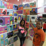 Shenia Mahase and Bentley Hines, both Tucker third-graders, show off their art work