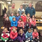 Joe DeBesse, Natasha Minsky, and Paul Cox with their group of smiling young skaters.