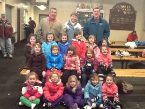 Joe DeBesse, Natasha Minsky, and Paul Cox with their group of smiling young skaters.