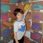 Luke Allen, a Tucker kindergarten student, reaches high to point to his masterpiece