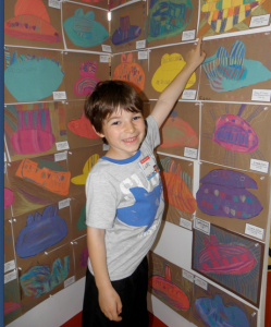 Luke Allen, a Tucker kindergarten student, reaches high to point to his masterpiece