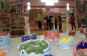 Pottery created by Glover third-graders in the foreground, as Tucker students tour the Copeland Field house, which was full of art from grades K-12