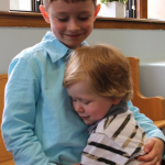 Thomas Monaghan is embraced by his little brother Myles after the celebration.