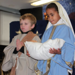 Braeden O'Brien (Milton) and Asmara Quartey (Quincy) play the roles of Joseph and Mary as they hold baby Jesus.